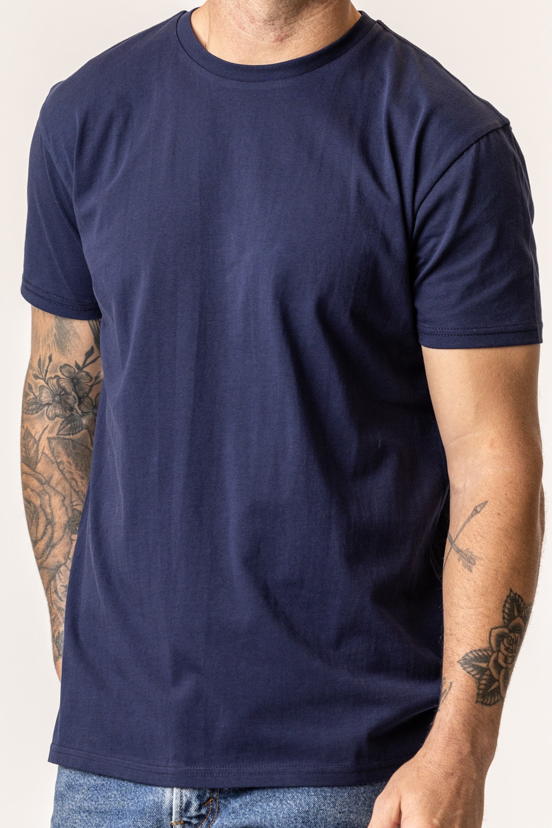 Person wearing a plain regenerative organic cotton in navy blue t-shirt color