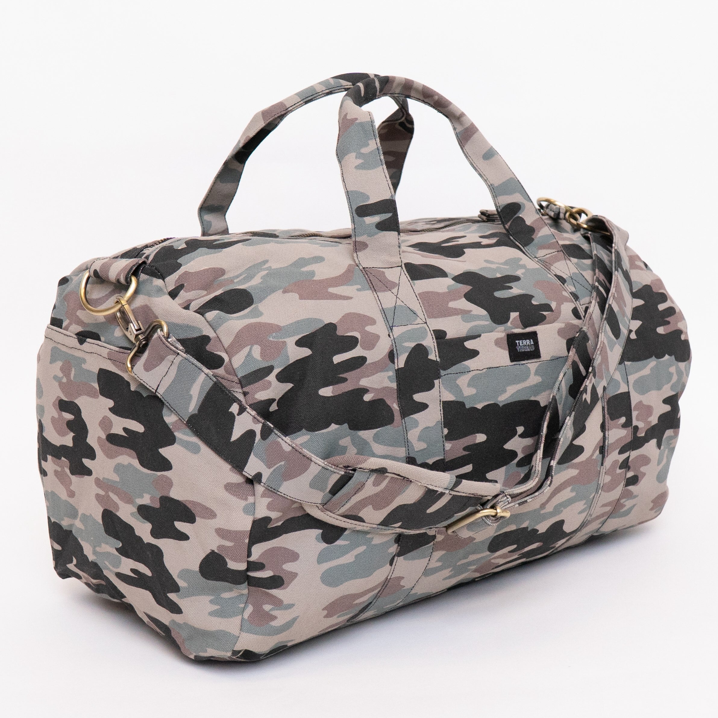 A duffel bag with a classic camouflage pattern in shades of beige, gray, black, and muted green, featuring dual top handles and a shoulder strap, set against a plain white background