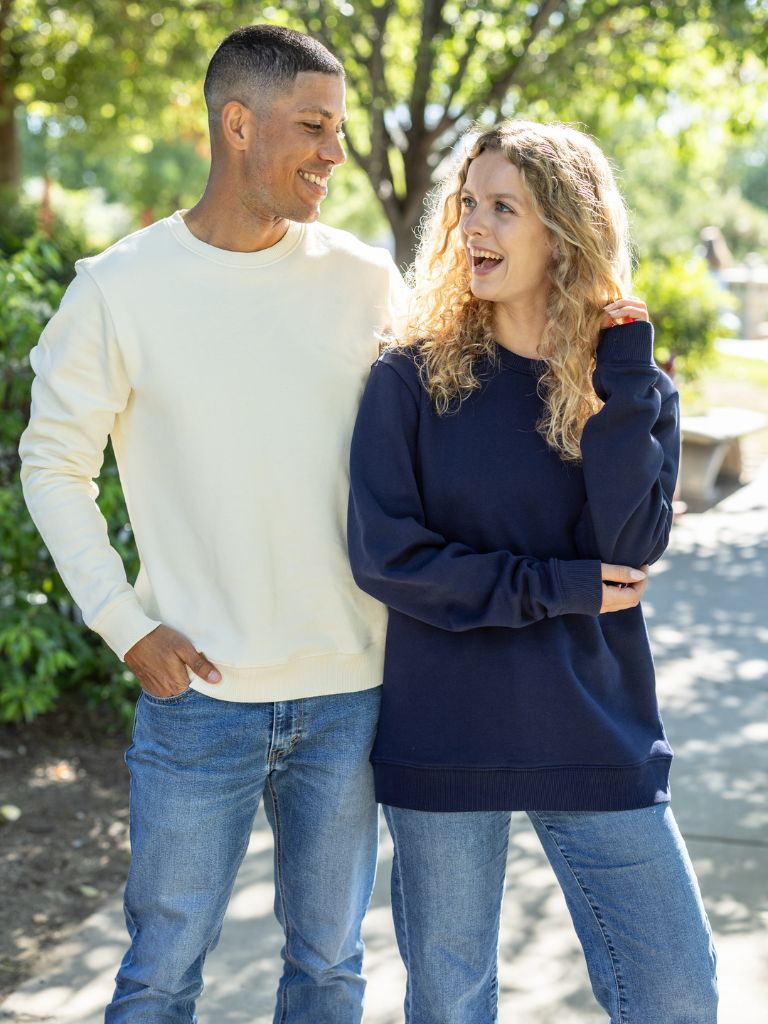 Two people wearing organic cotton sweatshirts in natural and navy blue color
