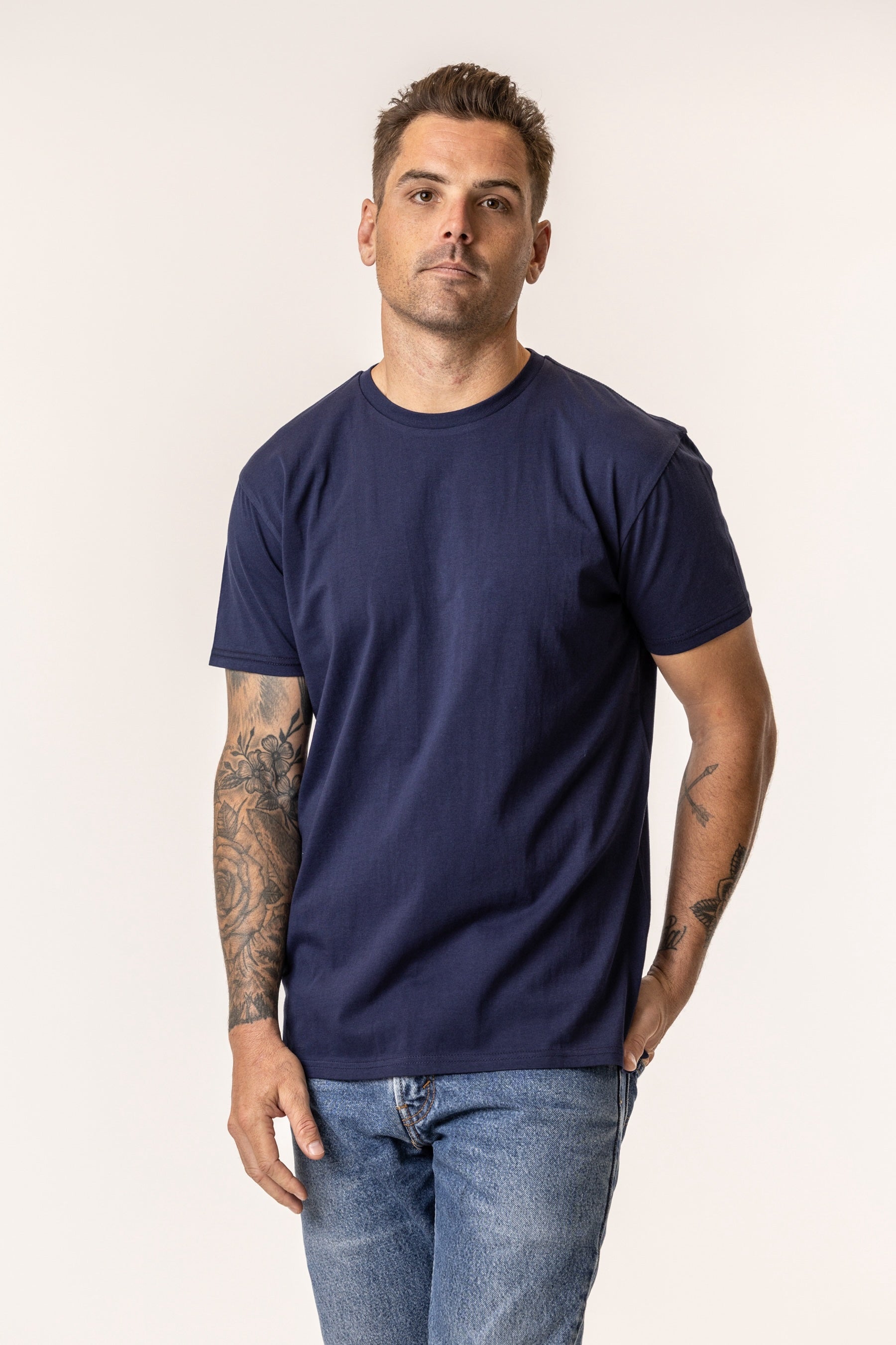 Man wearing a navy blue t-shirt made of regenerative organic cotton