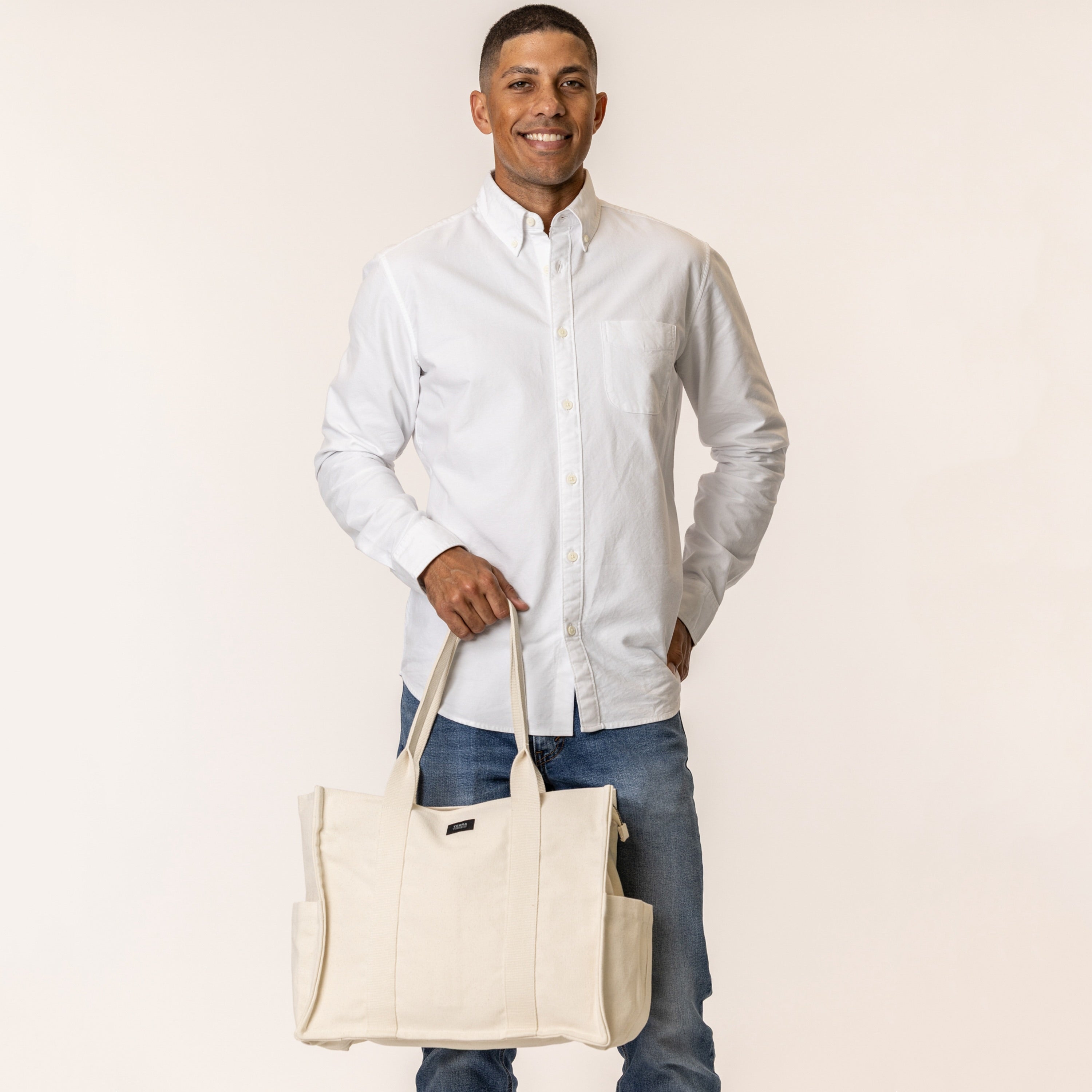 Man holding a natural color sustainable canvas purse