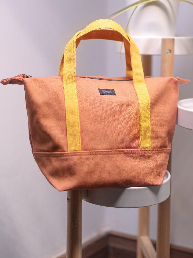 organic cotton mini tote bag in orange color with yellow handle and zipper handle