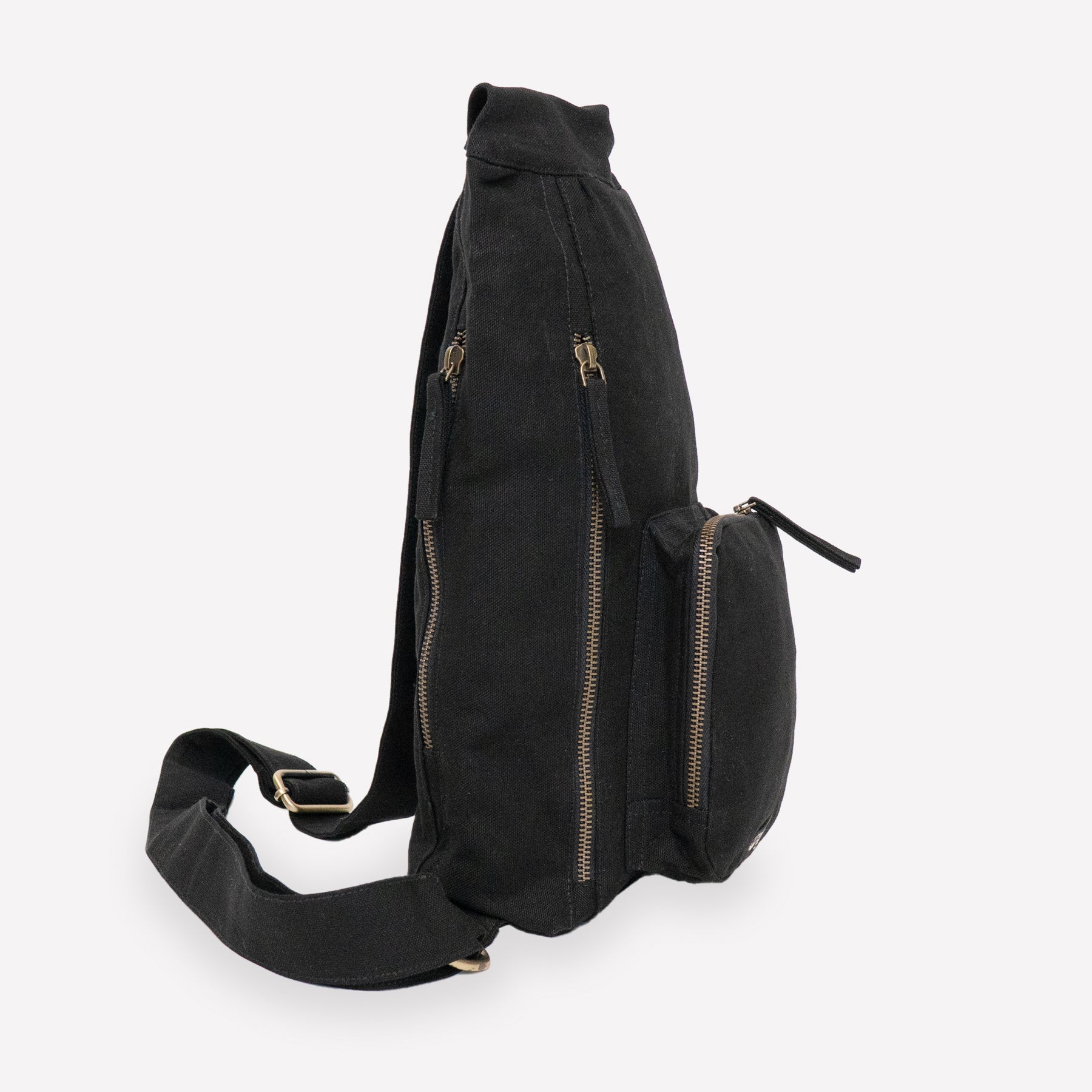 A black canvas sling backpack with pockets
