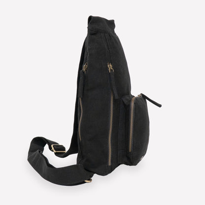 A black canvas sling backpack with pockets
