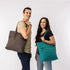 Man and woman holding brown and teal tote bags for work